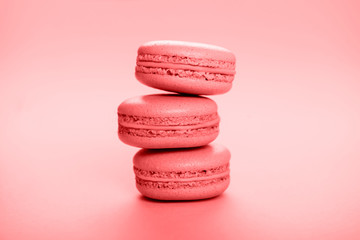 Living coral macaroons on pink background.