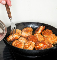 Homemade meatballs in frying pan with fork