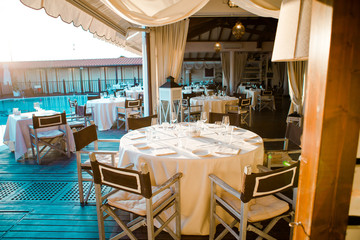 Summer empty outdoor restaraunt with white tablecloths