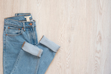 Blue jeans on a wooden background. Flat lay of female styled look. Top view. Shopping Concept....