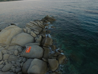 Aerial photography of the Sardinia coast during a summer sunset. Small waves on the rocks taken with a drone.