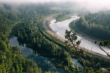 Railway near the river. Summer forest in the park
