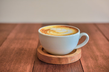 Latte art coffee on wooden table on coffee time