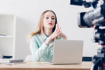 serious attractive female video blogger recording vlog in office