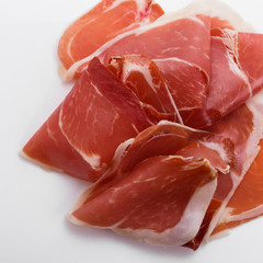 Italian prosciutto crudo or spanish jamon on a white background
