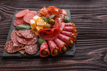 Cold smoked meat plate on a rustic wooden background