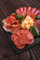 Cold smoked meat plate on a rustic wooden background