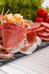 Cold smoked meat plate on a rustic wooden background