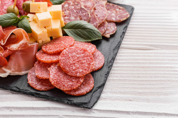 Cold smoked meat plate on a rustic wooden background