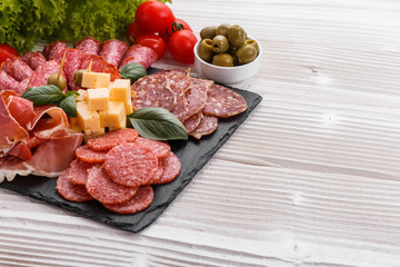 Cold smoked meat plate on a rustic wooden background