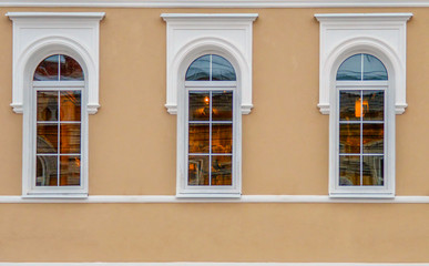 fragment of the facade of the old building after reconstruction, with three white arched-type windows