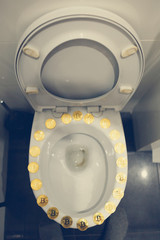 Bitcoin on the toilet. Metal Bitcoin physical currency.						