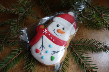 Christmas themed sweets and spruce branch on wooden table