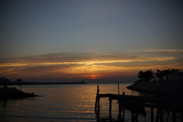 Fototapeta na wymiar silhouette of harbor ,Orange and red sky sunset on the beach.