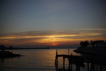 Fototapeta premium silhouette of harbor ,Orange and red sky sunset on the beach.