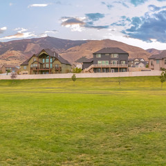 Lawn in front of homes with mountain in background