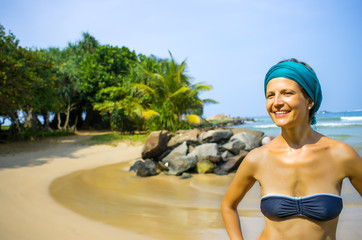 woman in fashion beachwear and hat on tropical beach on summer vacation travel.