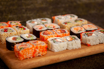 Sushi on a wooden deck with different fillings and seasonings