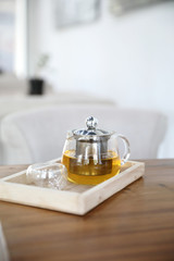 Hot teacup with teapot beverage on wooden table
