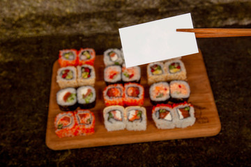 Sushi on a wooden deck with different fillings and seasonings