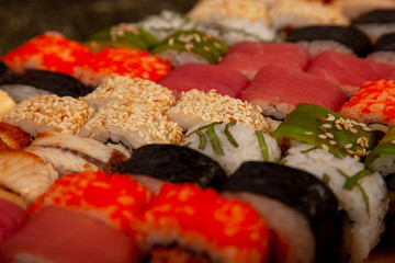 Sushi on a wooden deck with different fillings and seasonings