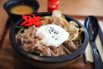 Japanese food Gyudon Japanese beef on rice bowl topped with egg on wooden table