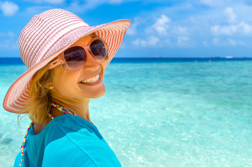 woman in fashion beachwear and hat on tropical beach on summer vacation travel.