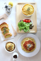 Spaghetti bolognese pie salad mash potato and bread in top view