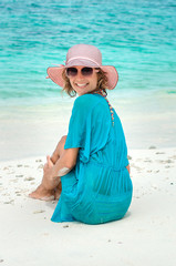 woman in fashion beachwear and hat on tropical beach on summer vacation travel.
