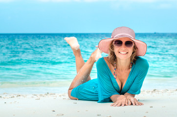 woman in fashion beachwear and hat on tropical beach on summer vacation travel.