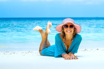 woman in fashion beachwear and hat on tropical beach on summer vacation travel.