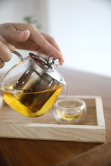 Hot teacup with teapot beverage on wooden table