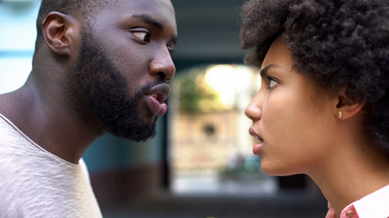 Young afro-american couple arguing outdoor, misunderstanding, jealous spouse