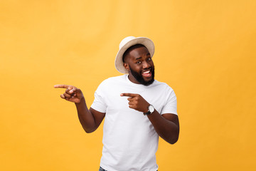 Funny young African customer smiling happily and pointing his index fingers at camera as if choosing you and inviting to big sale. Positive emotions, facial expressions, feelings. Selective focus.