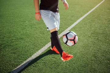 Cut view of man on play. He kicks ball with one feet. Guy play on football lawn alone.