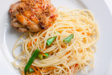 delicious dish. Baked chicken sprinkled with spices. spaghetti with butter and carrot and broccoli. selective focus. fresh and very appetizing dish. useful and proper nutrition. bright colorful colors