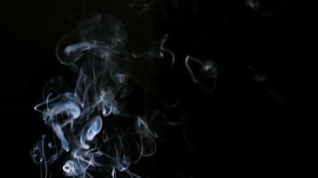 Cigarette smoke on a black background in slow motion