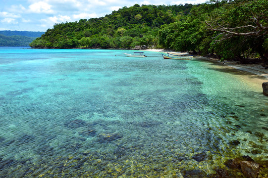 Remote And Tranquil Beach In Pulau Weh, Indonesia. Crystal Clear Water And Lush Green Water Front.