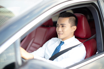 smiling  young business man  driving a car