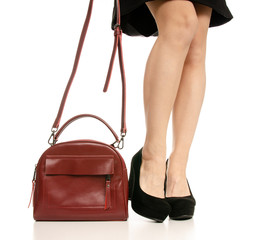 Woman legs feet black dress shoes red purse bag on white baclground isolation