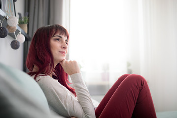 Young woman smiling and thinking about something at home