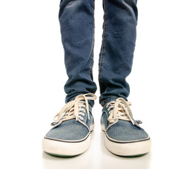 Man legs feet jeans sneakers on a white background. Isolation