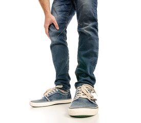 Man legs feet jeans sneakers on a white background. Isolation