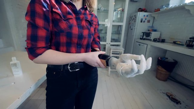 A woman puts on bionic hand, close up.