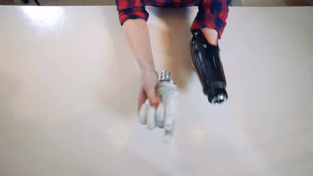 Person takes off a bionic hand, top view.