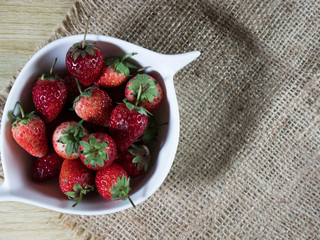 strawberries in a bowl on wooden table