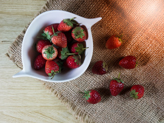 strawberries in bowl on wooden table