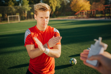 Young player is offered siggarettes. He holds hands crossed showing he doesn't want it. Young man...