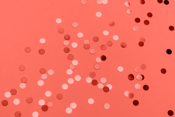 Beautiful festive coral background with confetti. Holiday decoration concept. Place for text. Color of the year 2019. Living coral.