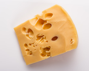 Piece and slices of cheese on a white background